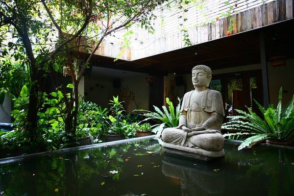 Bước qua cánh cổng gỗ mộc mạc của Fig – Lounge Café, điểm nhấn đầu tiên với khách là một hồ nước ở giữa sân, nổi lên trên là tượng Phật A-di-đà hướng ra phía ngoài