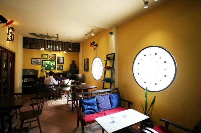 Gian bên phải quán cà phê nhà cổ The Home được thiết kế khép kín để chạy điều hòa. Hai ô cửa sổ tròn trên tường là điểm nhấn và cũng là nơi lấy ánh sáng tự nhiên.