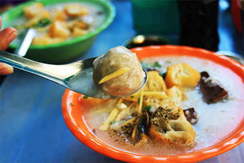 Tô cháo mang cho thực khách bắt mắt với màu xanh của hành lá, vàng của bánh quẩy, nâu của huyết và trắng tự nhiên của cháo. Ảnh: Phong Vinh