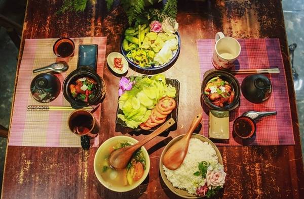 Nhiều du khách nước ngoài thích khám phá mâm cơm gia đình người Việt trong không gian nhiều hoa tươi.