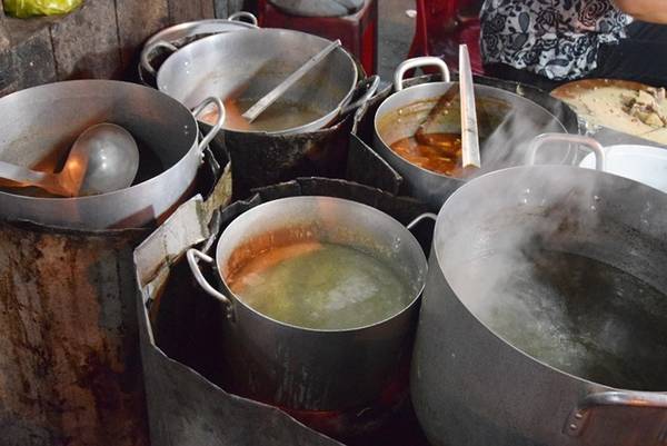 Năm nồi nước lèo cho bún bò, mì Quảng, cơm gà, cháo vịt luôn đặt trên bếp than hồng tại quán mì Quảng Mũi Né.