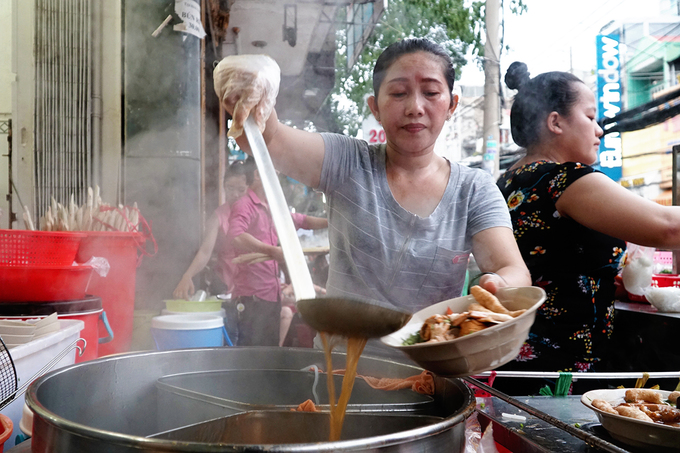 Gian bếp đặt ngay trước một căn nhà nhỏ, bày đủ thứ dụng cụ, nguyên liệu để nấu nướng. Các khâu được chia cho mỗi nhân viên để kịp phục vụ khách.  Quản lý quán chia sẻ, có hôm khách đông không đủ tô để bán. "Mỗi buổi tối, trung bình chúng tôi bán gần 1.000 tô tính cả ăn tại quán và mang đi. Có hôm cuối tuần bán nhiều hơn", người này cho hay.
