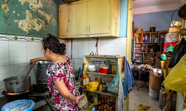 Bà Lê Thị Lang chuẩn bị món ăn tại quán vỉa hè Việt Nam. Ảnh: Guardian.