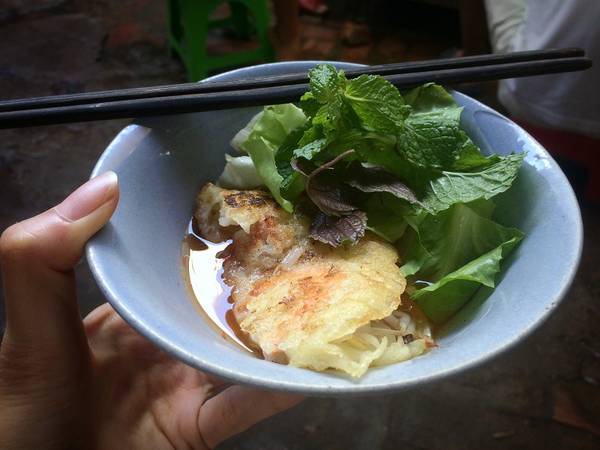 Điều lạ lẫm là bánh xèo không bày ra đĩa, mà đựng trong tô chan nước mắm sẵn và có dưa chua bên trong. Bánh xèo ăn cùng rau sống đựng trong những chiếc rổ nhỏ.