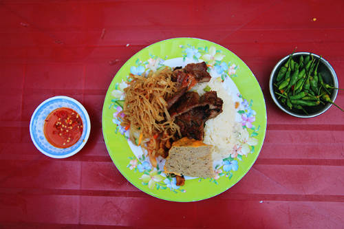 Dĩa cơm sà bì chưởng Sài Gòn với thịt sườn mềm, chả trứng, bì thịt, đồ chua và rau ăn kèm