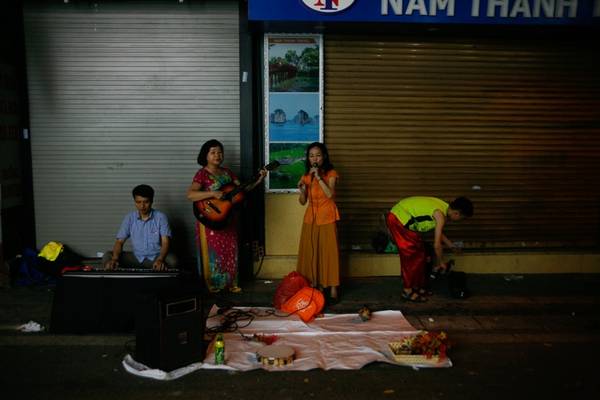 Nghệ sĩ tự do biểu diễn âm nhạc đường phố tại Hà Nội