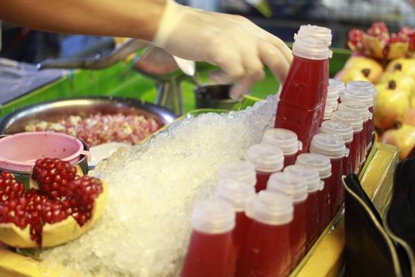 Nổi bật hai bên đường là những sạp nhỏ bán nước lựu ép mát lạnh.