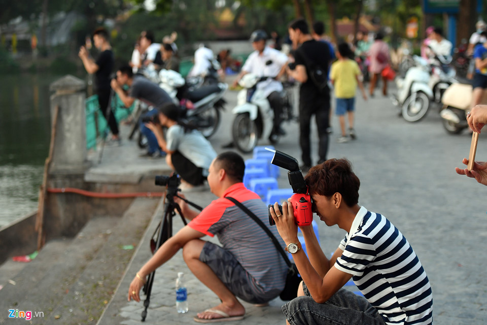 Trong đó có hàng chục tay máy săn cảnh hoàng hôn trải dài khắp vỉa hè bên lan can bờ hồ Tây. Một số người lên cả các nóc khách sạn gần đó sáng tác.