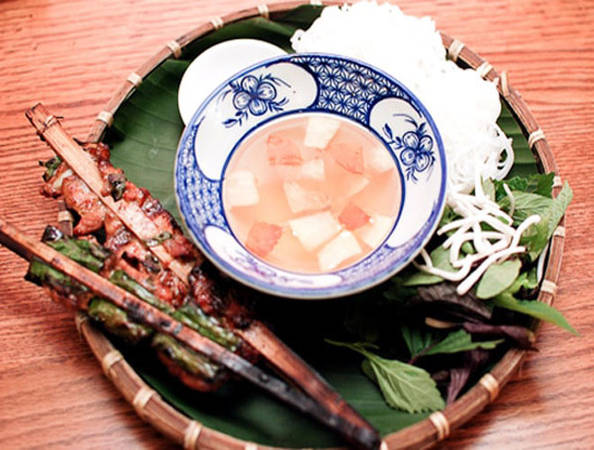 Ngõ chợ Đồng Xuân là một trong số ít nơi bán chả que tre ở Hà Nội. Món bún chả ở đây được làm theo phong cách cổ truyền: chả bọc lá lốt, kẹp que tre nướng trên than hoa. Thịt lợn ngọt quyện với vị thơm của lá lốt, hành phi và mùi dân dã của tre ám khói. Ngoài ra, điểm độc đáo nữa của quán là bún chả ở đây được ăn với giấm me, giấm sấu nên có vị khác biệt hẳn. Với 35.000 đồng, bạn đã có ngay một bát bún chả đầy đặn bún với 2 que chả miếng, 2 que chả băm lá lốt. Ảnh: Blogphuot.vn.