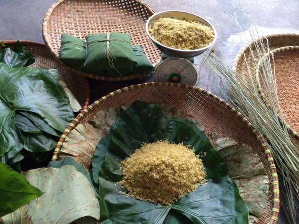 Cốm được gói trong hai lớp lá và buộc bằng những sợi rơm vàng tại làng cốm Mễ Trì - Ảnh: Huyền Trần