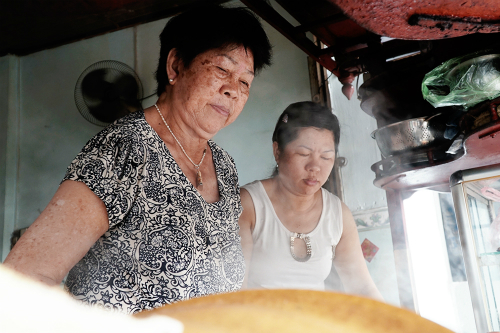 Vợ ông Há (trái) cùng con gái đang chuẩn bị món ăn cho khách. Ảnh: Di Vỹ.