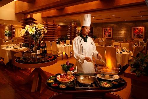 Ngoài rượu, có thể thêm một số loại gia vị khác như hành lá, gừng tươi xắt nhỏ hoặc tỏi ớt để khử mùi tanh và tăng thêm hương vị cho món ăn. Khi tôm bắt đầu "uống rượu", chúng sẽ giãy giụa và có thể nhảy ra khỏi bát. Đậy nắp lại và ngâm tôm trong khoảng 15 phút cho ngấm hẳn rượu. Khi tôm đã mềm và không còn nhảy nữa, người đầu bếp châm lửa đốt rượu trong vòng đúng 30 giây, đủ để lớp vỏ tôm chuyển màu đỏ gạch mà không làm mất đi độ ngọt. Lúc này, hương thơm nồng của rượu hòa quyện trong vị ngọt thanh, mọng nước của tôm sẽ làm say lòng mọi thực khách. Ảnh: Starworldmacau.com.