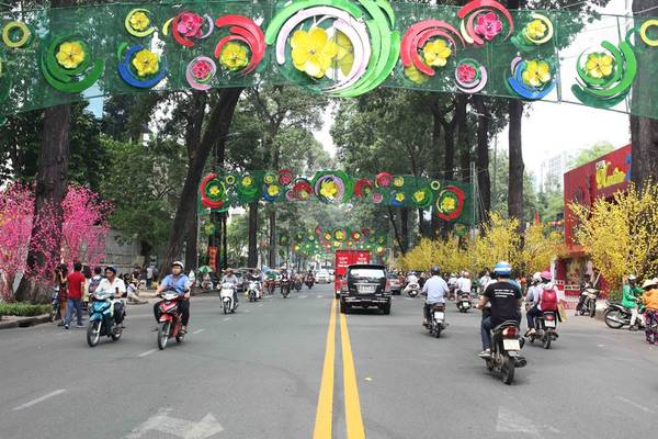 Đường Phạm Ngọc Thạch, phía trước Nhà văn hoá Thanh niên TP.HCM, được trang trí rực rỡ với một bên hàng cây hoa đào, một bên mai vàng, thu hút rất đông người dân đến chụp ảnh.