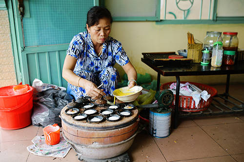 Bên chiếc lò đúc nóng ấm, chiếc bánh căn vừa chín tới có màu vàng, vừa mềm vừa chút giòn giòn sựt sựt để lại trong lòng khách phương xa nhiều ấn tượng khó quên. Ảnh: Phong Vinh