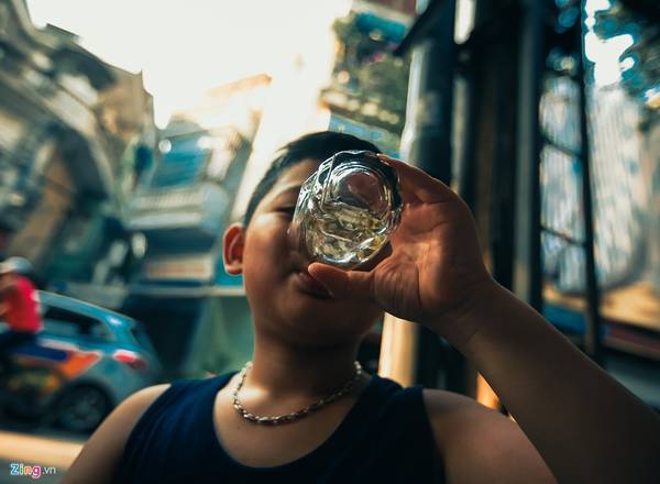 Em bé uống nước xanh tại phố Hàng Tre