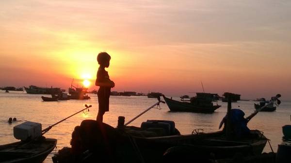 Cậu bé đứng ngắm hoàng hôn ở bến cảng Hòn Thơm.