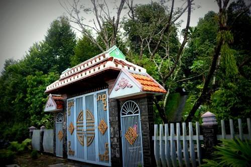 Bờ đá và hàng chè tàu chạy dài sau cánh cổng, dẫn vào ngôi nhà cổ lâu đời nhất làng Lộc Yên