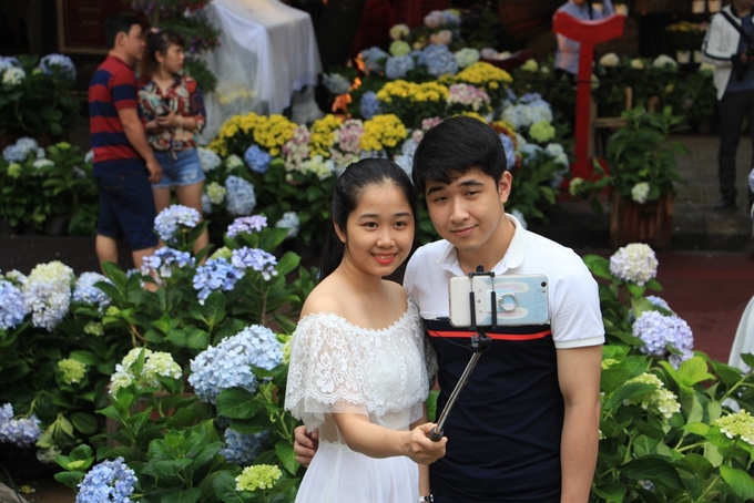 Đôi bạn trẻ selfie bên trong vườn hoa cẩm tú cầu.